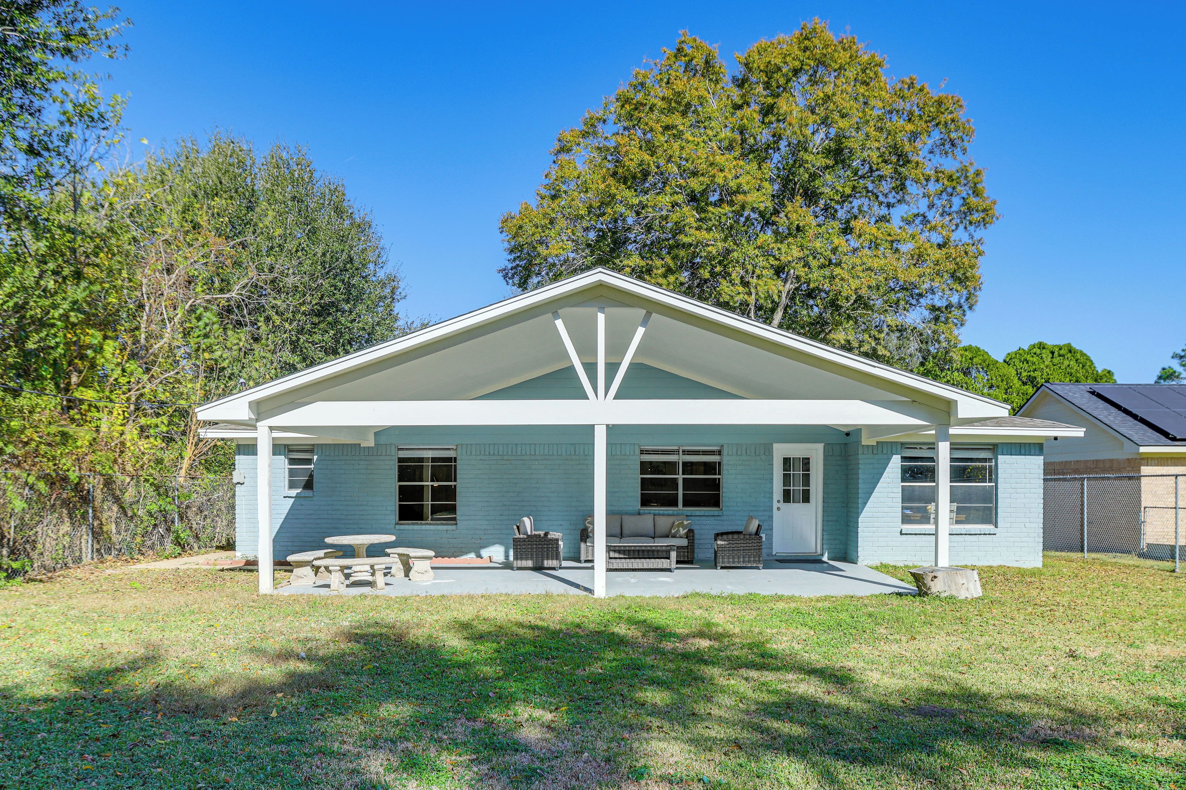 A single-story house with a covered porch, a small patio area, and a lawn.