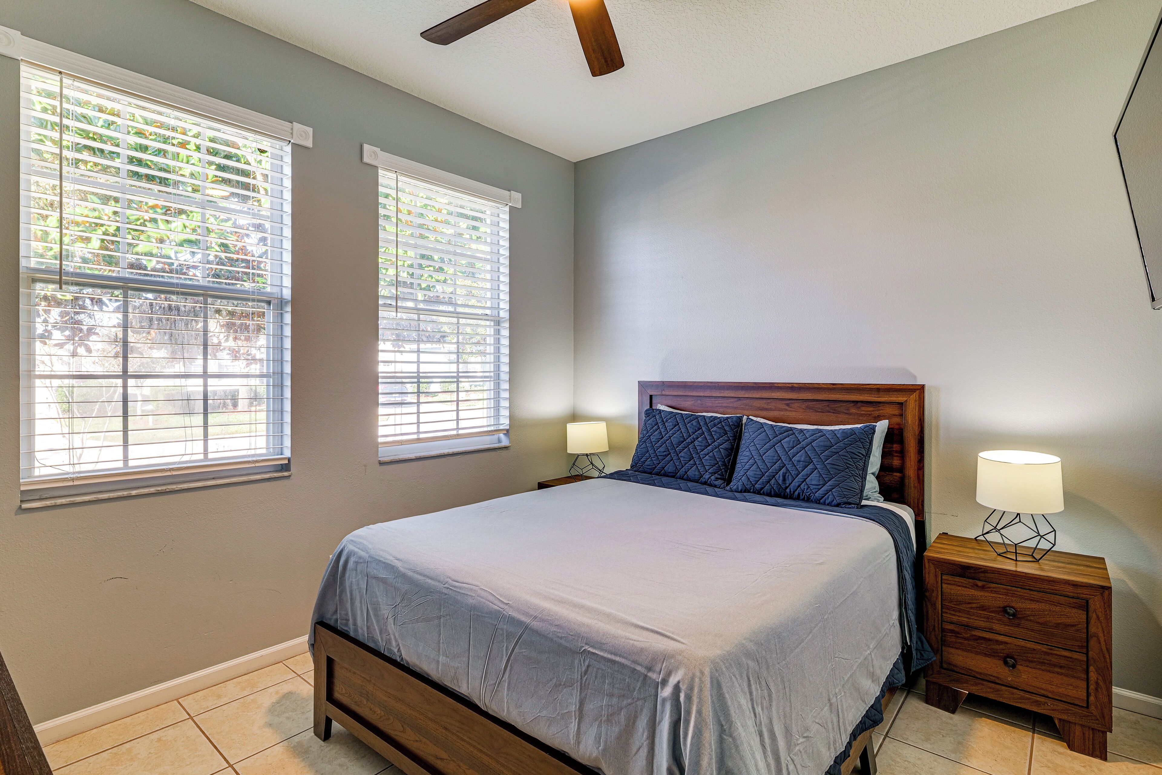 A bedroom with a bed, two bedside tables, and a ceiling fan.