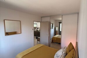 Ein Schlafzimmer mit einem Bett, einem Kleiderschrank und einem Spiegel.