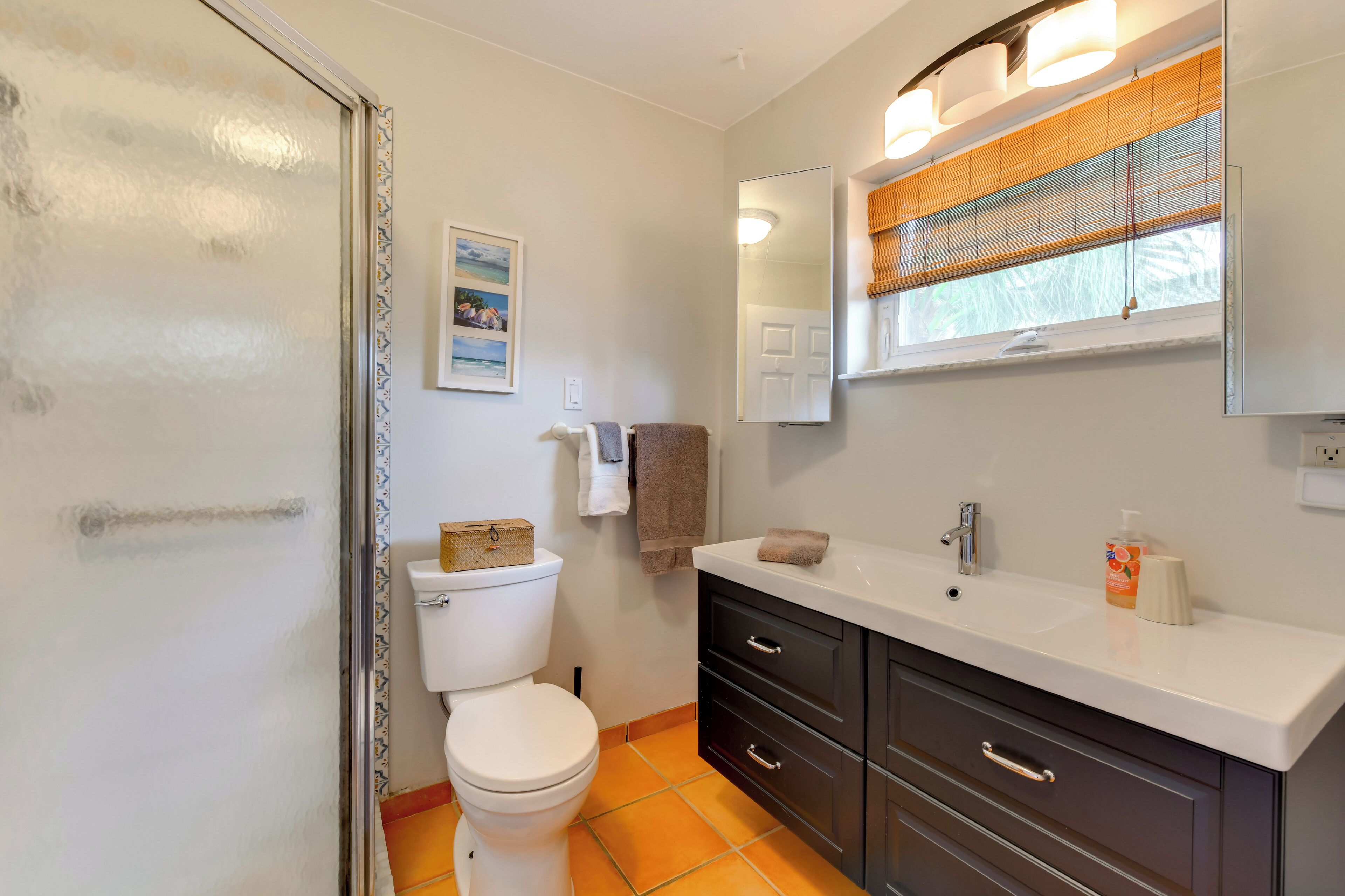 A bathroom with a toilet, sink, and cabinet.