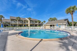 A swimming pool with lounge chairs and umbrellas, surrounded by a building with balconies and palm trees. - Walkable Beach Retreat! Miramar Resort Condo (Miramar Beach)