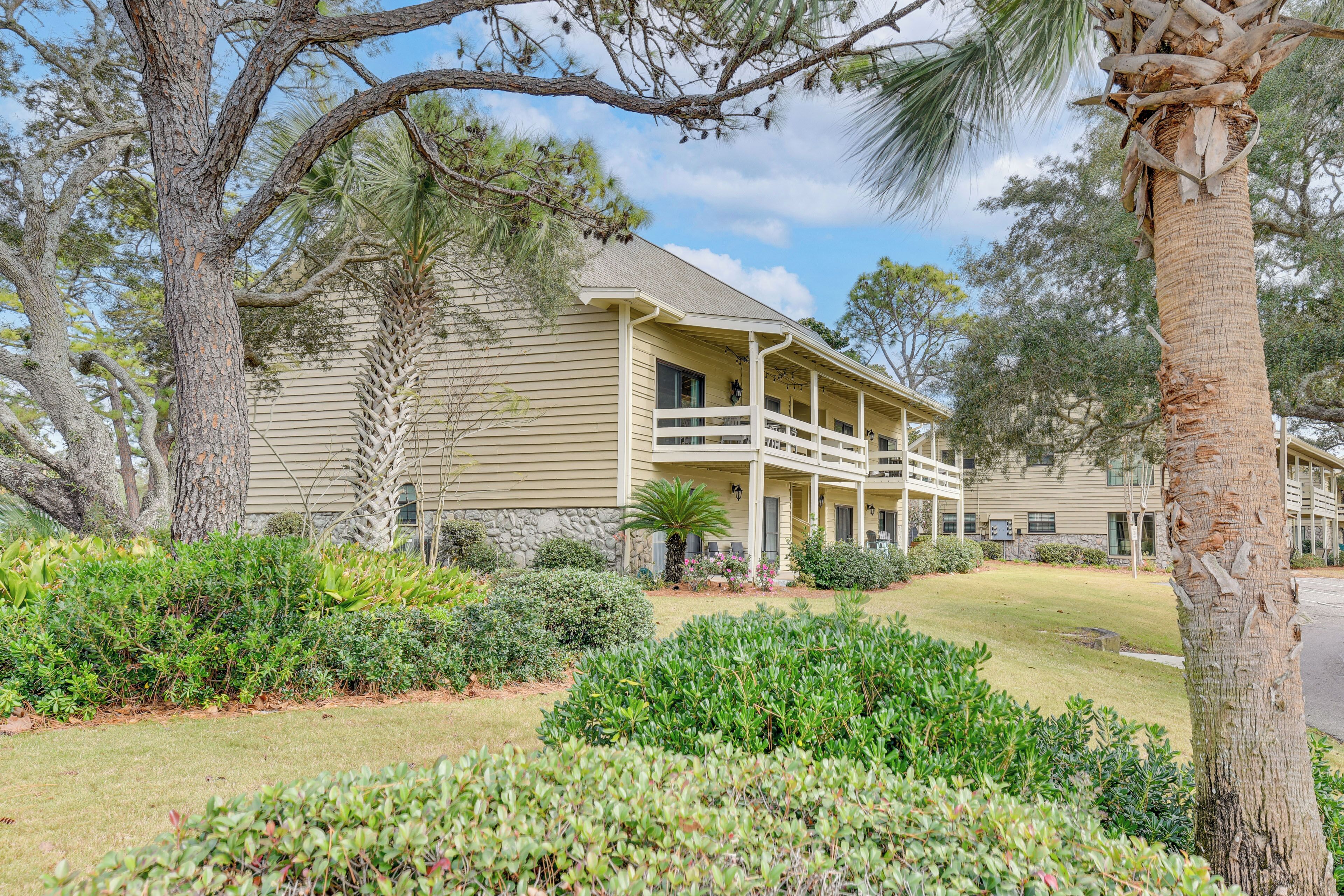 A two-story building with a covered porch and a landscaped front yard.