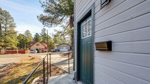 Ett bostadshus med en grön dörr, en brevlåda och en dörrmatta.