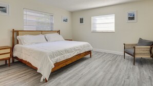 A bedroom with a wooden bed, a rattan chair, and a small bedside table. - Walk to Shops & Eats, 3 Mi to Beach! Hollywood Gem (Hollywood)