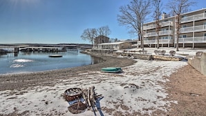 A waterfront property with a dock, a snow-covered beach, and a building with balconies. - Balcony w/ Lake Views: Waterfront Ozarks Condo! (Osage Beach)