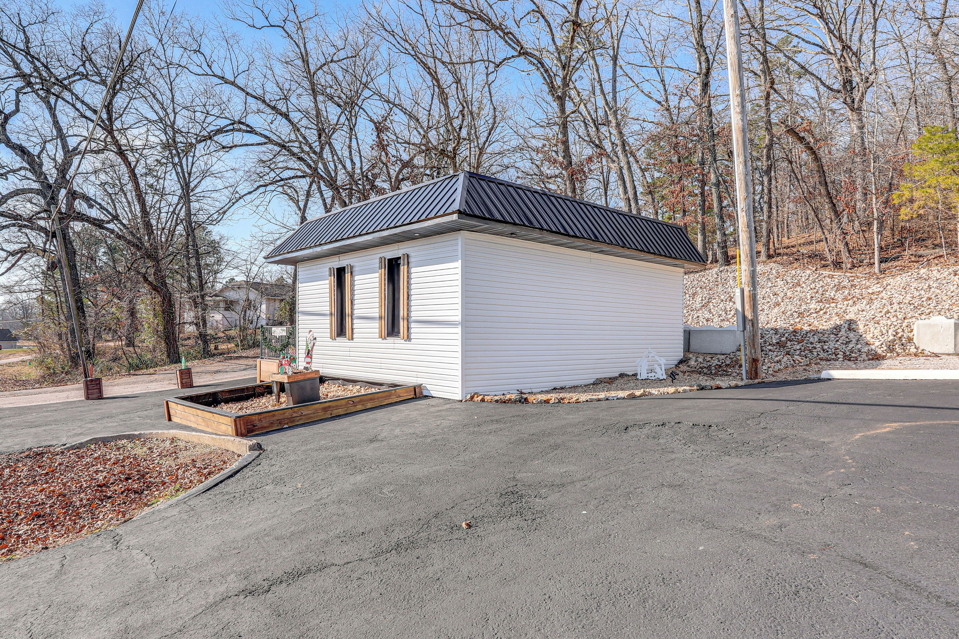 A small, single-story house with a dark roof and white siding.