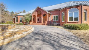 A brick house with a stone fountain, large windows, and a well-maintained lawn. - Scenic Lagrange Retreat! 3,600 Sq Ft, Pool Access (LaGrange)
