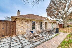 A brick house with a patio area featuring outdoor furniture and a stone pathway. - Dallas Area Home w/ Hot Tub, Families Welcome! (Duncanville)