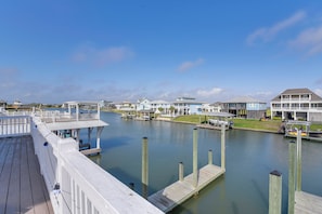 A waterfront property with a wooden deck, dock, and marina. - Walk to Beach! Bayfront Port Bolivar Home w/ Dock (Port Bolivar)