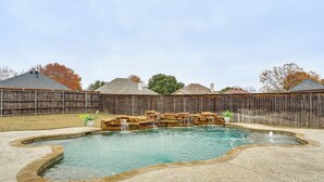 A backyard with a swimming pool, a wooden fence, and a stone patio. - Group-friendly Burleson Getaway w/ Outdoor Oasis (Burleson)