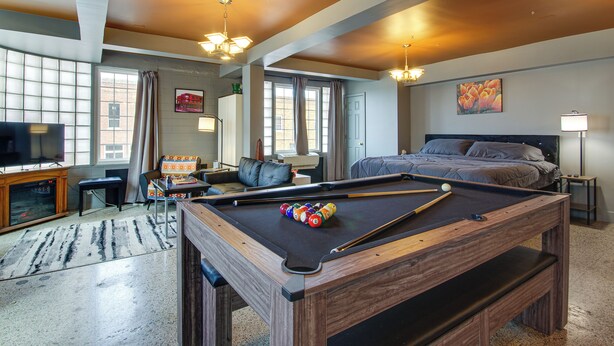 A hotel room with a pool table, a bed, a television, and a large window. - Unique Studio in Downtown Lebanon, Pets Welcome! (Lebanon)