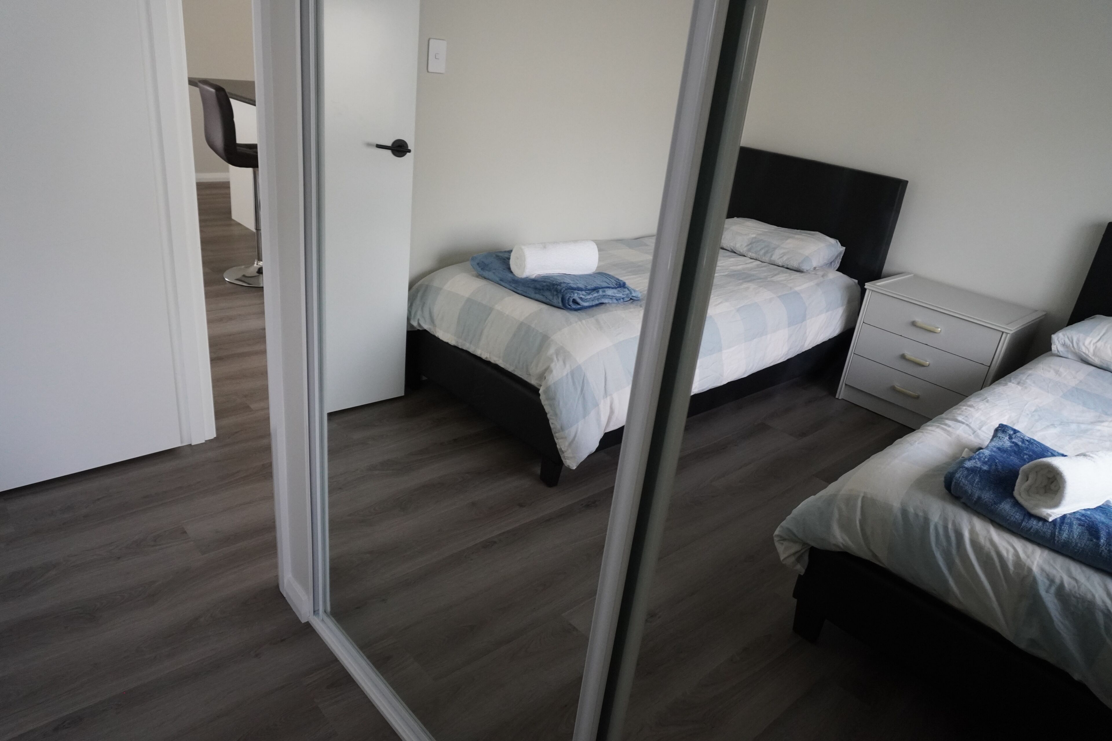 A hotel room with two beds, a desk, and a chair.