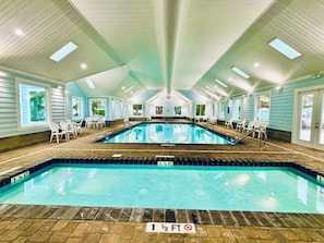 An indoor swimming pool with clear water, surrounded by white chairs and a tiled floor. - 256 Melody Gardens (The Glitzy Mermaid) (Surfside Beach)