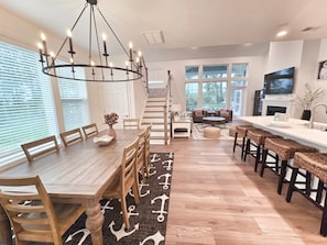 Eine geräumige Küche mit Essbereich, Holzmöbeln und einer Kristallleuchter.