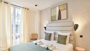 A hotel room with a bed, a chair, a toilet, and a window with curtains. - Sublim Apartment Paris Center Beaubourg Le Marais (Paris)