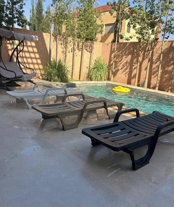 A pool area with lounge chairs and a yellow float. - Luxury escape: private villa 12 minutes from Jemaa el-Fna square (Marrakech)
