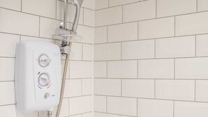 Eine Dusche mit Handbrause und einer fest installierten Bedienkonsole.