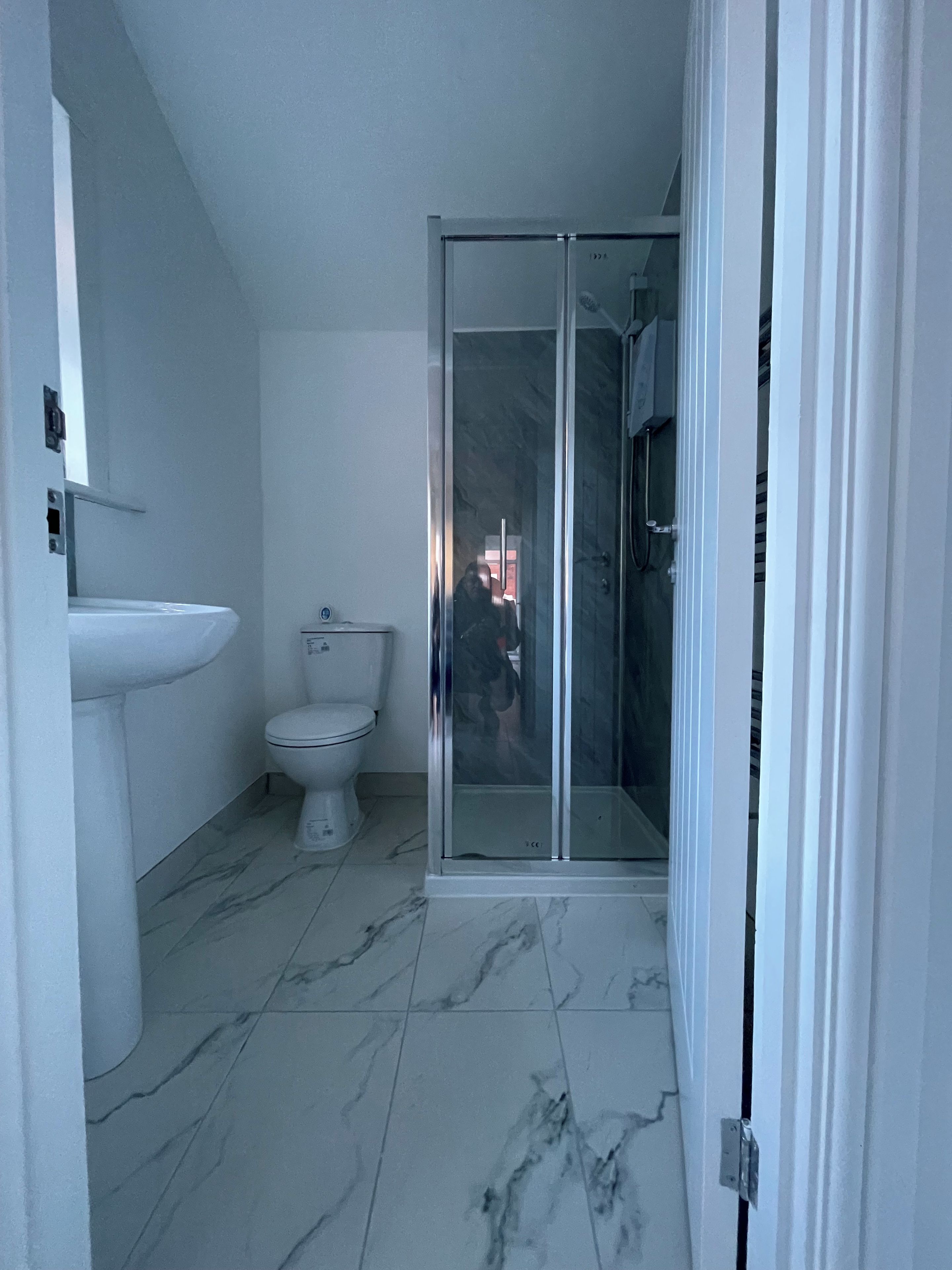 A bathroom with a toilet, a sink, and a glass-enclosed shower area.