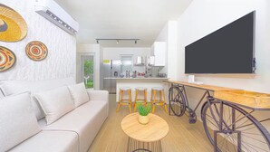 A modern living room with a sofa, a round coffee table with a plant, and a bicycle. - Reef Townhouse Tides -T39- (Punta Chame)
