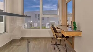 Eine moderne Küche mit einer Holzausziehtheke, einem Stuhl und einem Fenster mit Blick auf Gebäude.