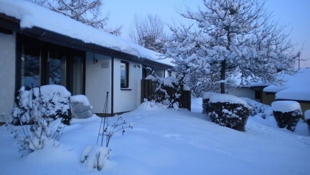 Ein verschneites Wohngebiet mit einem Haus, einer Garage und einer Auffahrt.