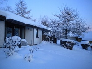A snow-covered residential area with a house, a garage, and a driveway. - Vacation Home in Hohenlupfen (67) - Meiß Öfingen (Bad Dürrheim)