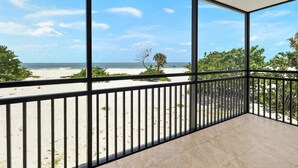 Ein Balkon mit Blick auf Strand und Meer.