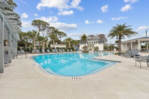 Una piscina amb gandules i un edifici al fons.