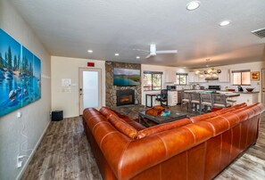 A modern living room with a leather sofa, a fireplace, and a stone wall.