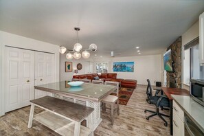 Un amplio espacio habitable con una mesa de comedor, un sofá y una televisión.