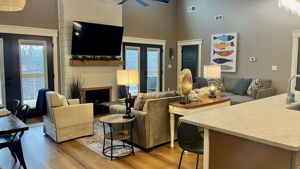 A spacious living room with a fireplace, a large TV, and a dining area.