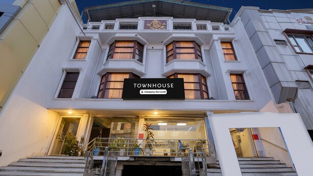Un edificio con un letrero que dice 'TOWNHOUSE' y el logotipo de Company-Servicod.