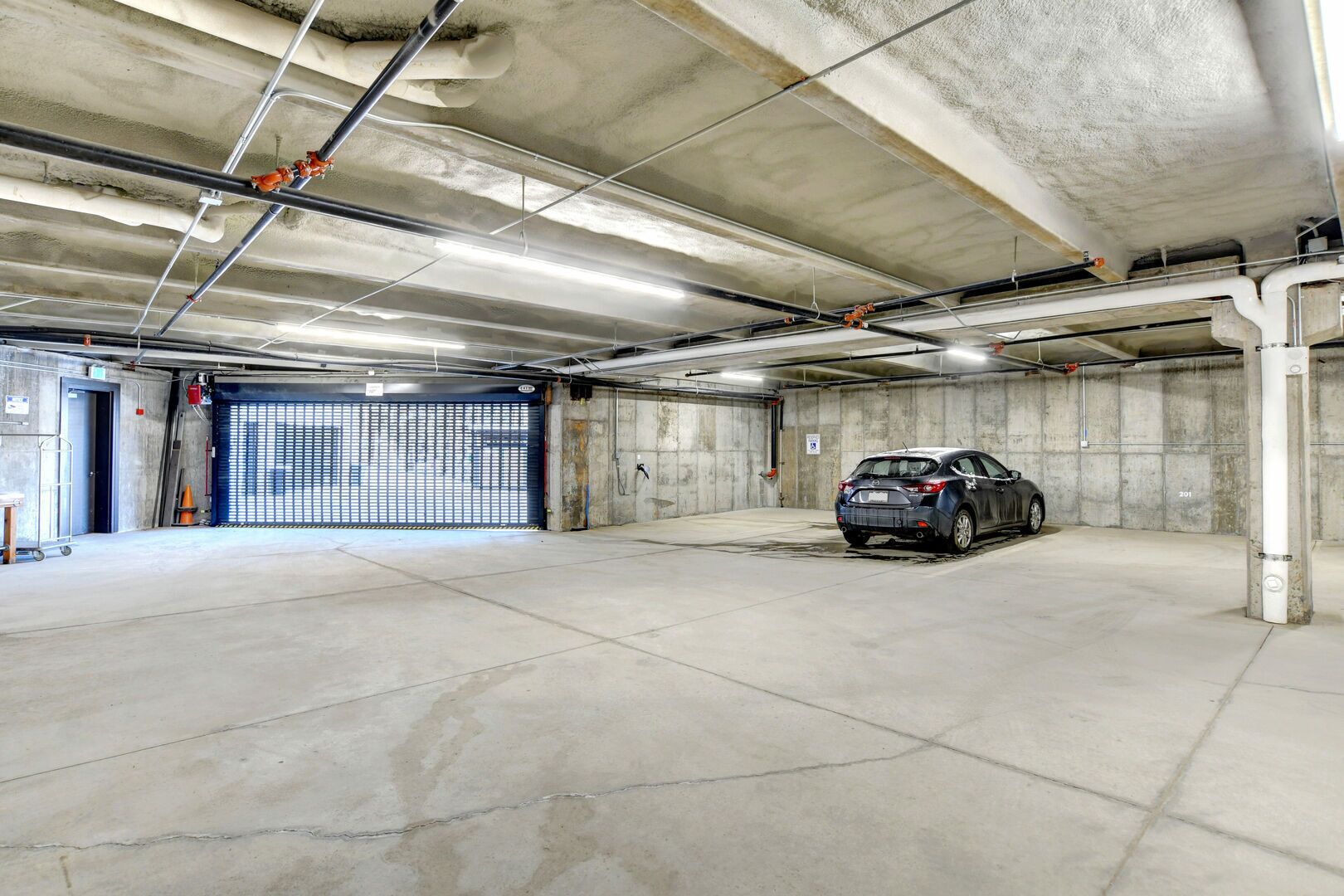 A parking garage with a car parked in one of the spaces.