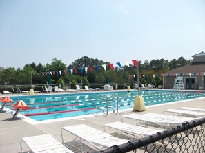 A swimming pool with multiple lanes, lounge chairs, and a lifeguard stand. - 908 Dover - Sea Colony East (Bethany Beach)