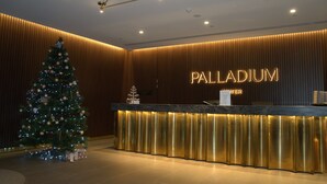 Bancada de recepção com árvore de Natal e uma placa com a inscrição 'PALLADIUM'.