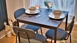 Et spisebord med to skåle og to glas med en lyserød drik, dækket med bestik.