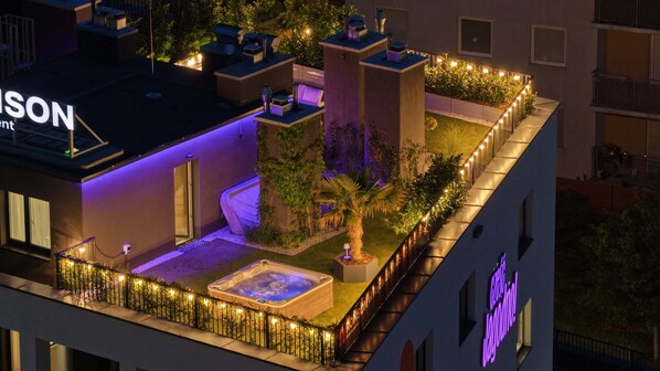 Un jardin sur le toit équipé d’un jacuzzi, d’un espace salon et d’une enseigne indiquant « GROHE VOGUM ».