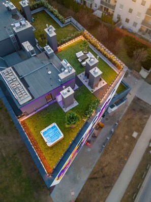 Un toit-terrasse doté d’une piscine, d’un espace salon extérieur et d’un jardin bien entretenu.