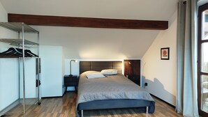 A bedroom with a bed, a nightstand, a wall-mounted shelf, and a window with curtains. - Old Town Apartment Luka (Roding)