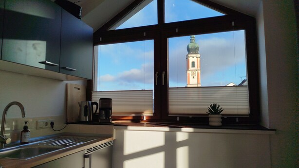 A kitchen with a window overlooking a tower. - Old Town Apartment Luka (Roding)
