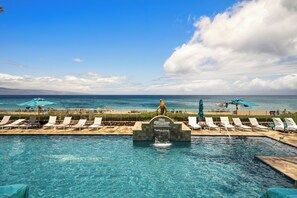 Une piscine avec des chaises longues et des parasols, une enseigne indiquant « The Whaler », et une vue sur l’océan.