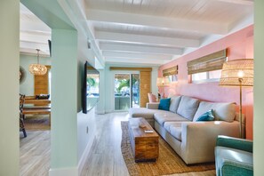 A modern living room with a sectional sofa, a coffee table, and a large window. - Trip Around the Sun 2/2 + dockage & Cabana Club (Key Colony Beach)
