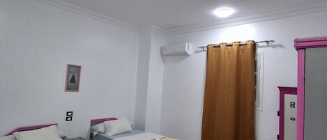 Une chambre avec deux lits, une salle de bain et un miroir.