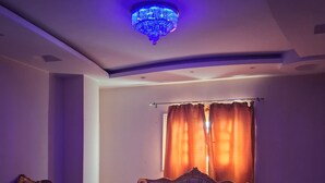 A living room with a sofa, two armchairs, a coffee table, and a ceiling light fixture. - El Agamy Hotel Apartment (Luxor)