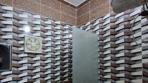 A bathroom with a shower, toilet, sink, and a hand dryer. - El Agamy Hotel Apartment (Luxor)