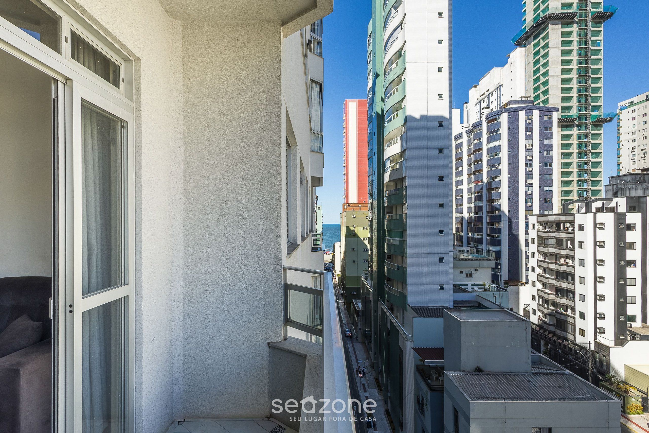 A high-rise building with multiple balconies and a clear view of the surrounding urban area.