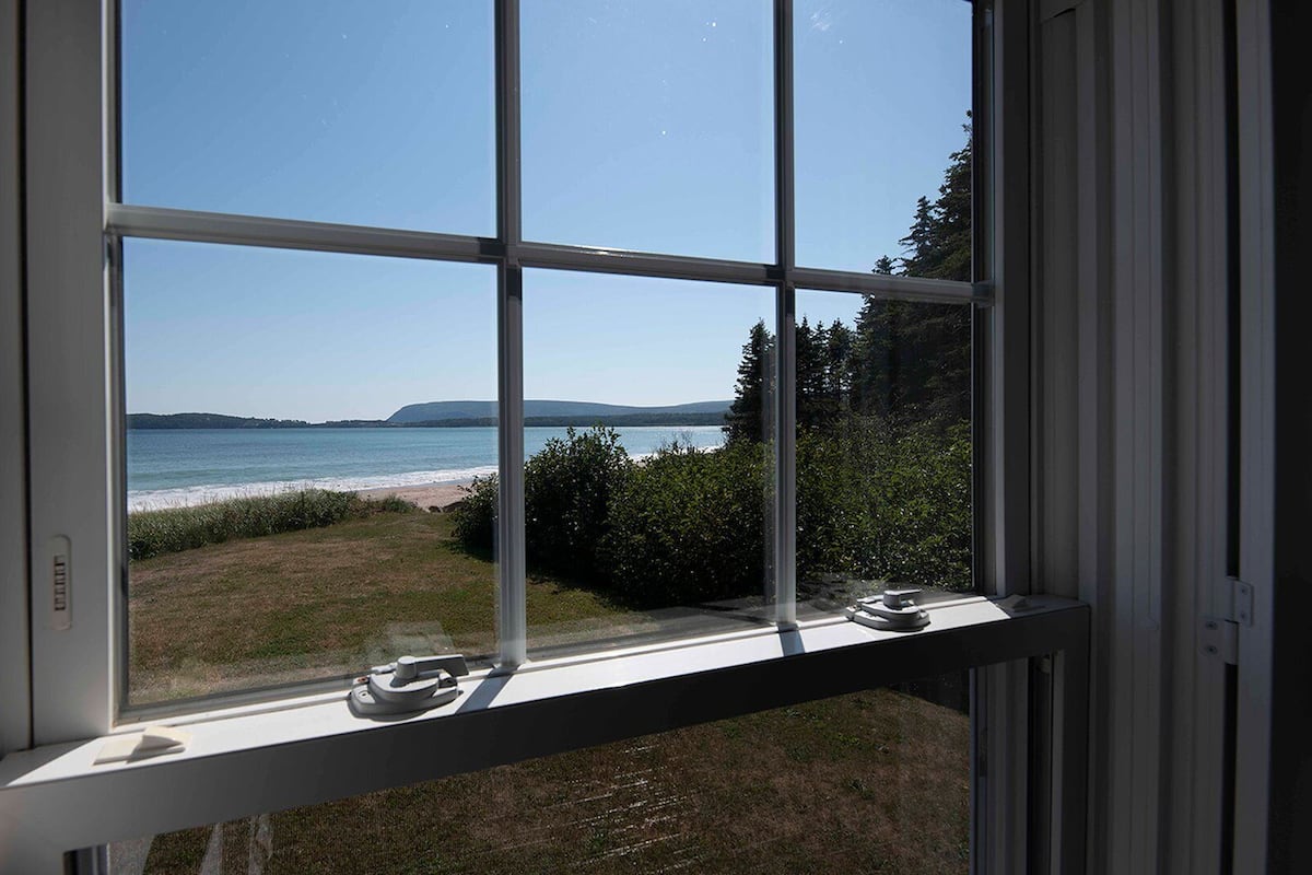 A window with a view of a beach and ocean.