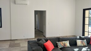 A modern living room with a grey sectional sofa, a red pillow, and patterned cushions. - Villa 8 people - Peace & comfort (Ghisonaccia)