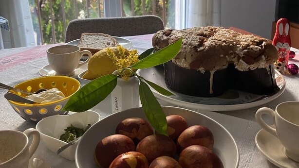 Ein Esstisch mit Kuchen, Pfirsichen in einer Schüssel und einer Teetasse.