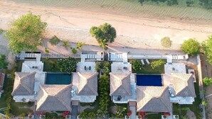 Un resort con varias villas, cada una con piscina privada y rodeadas de exuberante vegetación.